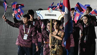 Members of Cambodia's delegation wave their nation's national flag as they take part in the athletes' parade during the opening ceremony of the 33rd Southeast Asian Games at Rajamangala National Stadium in Bangkok (Picture credit: AFP)