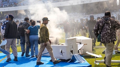Smoke erupts after chairs were set on fire amid chaos during an event of Argentine footballer Lionel Messi as part of his 'G.O.A.T. India Tour 2025', at Vivekananda Yuba Bharati Krirangan in Kolkata on December 13, 2025. (Image: PTI)