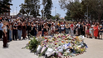 Mourners gather by floral tributes at the Bondi Pavillion in memory of the victims of a terror attack at Bondi Beach, in Sydney. (Image: AFP)