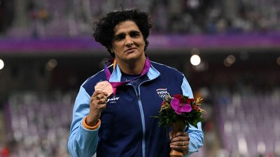 Seema Punia celebrates on the podium during the medal ceremony for the women's discus throw final athletics event during the 2022 Asian Games (Picture credit: AFP)