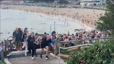People fleeing Bondi Beach after gunmen opened fire in Sydney  on Sunday. (AFP)