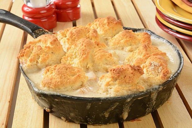 While puff pastry dough works for the skillet chicken pot pie, biscuit dough is preferred. It keeps the filling intact, adds structure, and delivers a crispier, golden crust that enhances the overall texture and taste.