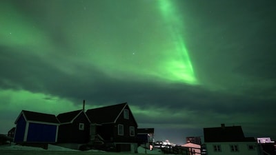 Northern Lights glow above the city of Nuuk during a power outage. (Photo by Jonathan NACKSTRAND / AFP)