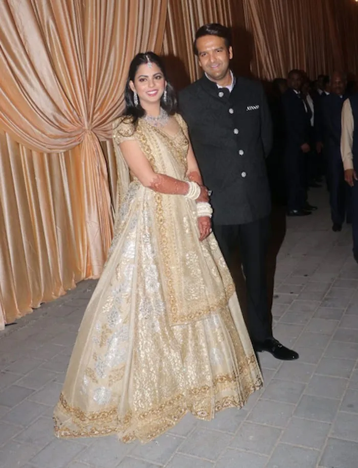 In 2018, for her post-wedding reception in Mumbai, Isha Ambani wore a custom lehenga designed by Maison Valentino. This was the first and only time the Italian fashion house ventured into Indian bridal couture. The lehenga featured floral motifs and intricate gold embroidery, blending Valentino’s European craftsmanship with Indian tradition. The look was celebrated as a milestone in global fashion collaboration. In 2018, for her post-wedding reception in Mumbai, Isha Ambani wore a custom lehenga designed by Maison Valentino. This was the first and only time the Italian fashion house ventured into Indian bridal couture. The lehenga featured floral motifs and intricate gold embroidery, blending Valentino’s European craftsmanship with Indian tradition. The look was celebrated as a milestone in global fashion collaboration.