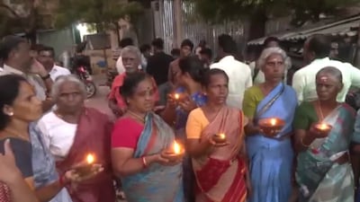 People from Palani Andavar Temple Street stood in front of the Palani Andavar Temple holding lamps and raised slogans. (ANI)