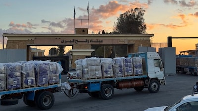 Trucks loaded with humanitarian aid on the Egyptian side of the Rafah crossing wait to cross into the Gaza Strip. (AFP file photo)