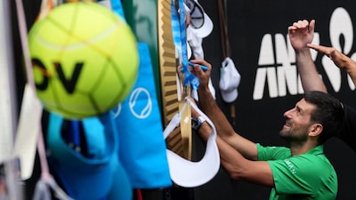 Novak Djokovic of Serbia signs autographs after his quarterfinal match against Lorenzo Musetti of Italy at the Australian Open tennis championship in Melbourne, Australia, Wednesday, Jan. 28, 2026. (AP Photo/Dar Yasin)