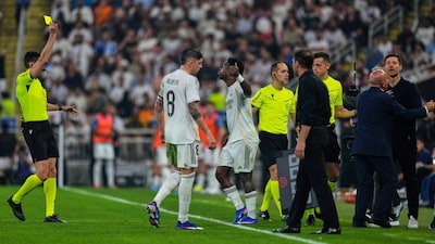Real Madrid's Vinicius Junior, third from right, receives a yellow card during the Spanish Super Cup semifinal soccer match against Atletico Madrid at King Abdullah Sports City Stadium in Jeddah, Saudi Arabia, Thursday, Jan. 8, 2026. (AP Photo/Altaf Qadri)