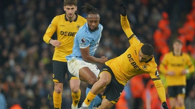 Manchester City's Antoine Semenyo, center tackles Wolverhampton Wanderers' Andre during the English Premier League soccer match between Manchester City and Wolverhampton Wanderers in Manchester, England, Saturday, Jan. 24, 2026. (AP Photo/Ian Hodgson)