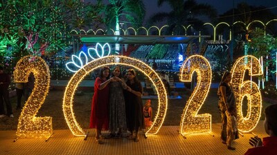 Revellers pose for photographs at an illuminated sea promenade during New Year's Eve in Mumbai. (AFP)