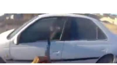 A video grab of an assailant firing shots at a cop car. (X)