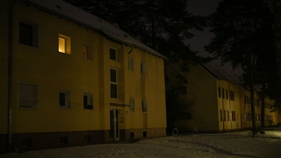 Dimly lit residential buildings are seen in the Schlachtensee district during the massive power failure in southwestern parts of the German capital on the evening of January 6, 2026. (AFP)