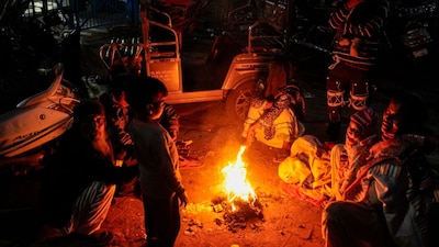 People sit around a small fire to keep themselves warm on a winter evening, in New Delhi, Monday, Jan. 12, 2026. (PTI)