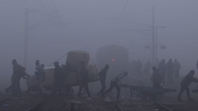 People walk amid dense fog, affecting visibility on a winter morning. (Reuters)