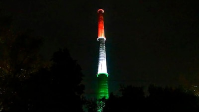 The 166-metre Rajghat Power Plant chimney tower, which has been repurposed as a city landmark, stands illuminated in New Delhi. (Image: PTI/File)