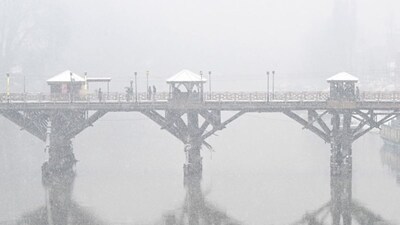 Pedestrians cross a bridge after a spell of fresh snowfall at the Dal lake in Srinagar on January 27, 2026. (AFP via Getty Images)