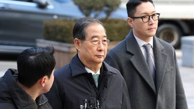 Former South Korean prime minister Han Duck-soo (C) arrives at the Seoul Central District Court for his first sentencing trial. (AFP Photo)