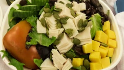 United Airlines’ first-class meal, featuring a simple tray of salad, cheese cubes, meat and a whole tomato, has triggered widespread outrage online.