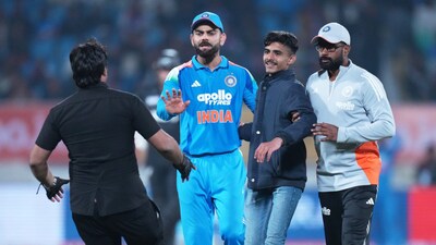 Virat Kohli urges restraint as a security person approaches to catch pitch invader. (AP Photo)