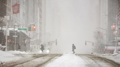 A pedestrian walks on a street as snow falls during a winter storm in New York City on Monday. (Image: Reuters)