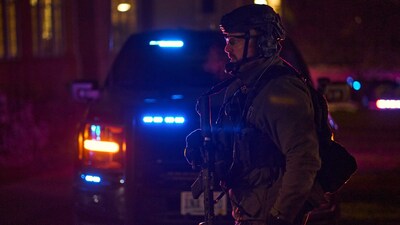 A police officer walks past a squad car outside a temporary family reunification site at Nelson Fitness Center at Brown University in Providence, Rhode Island (AFP Photo)