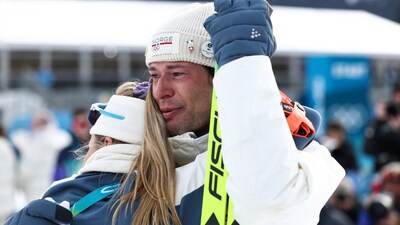 Bronze medallist Norway's Sturla Holm Laegreid (R) is hugged following the victory ceremony of the men's biathlon 20km individual event during the Milano Cortina 2026 Winter Olympic Games (AFP)