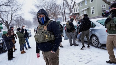 A member of the Enforcement and Removal Operations of ICE stands guard while a man is detained by ICE agents during an immigration raid, in Minneapolis, Minnesota, US. (IMAGE: REUTERS)
