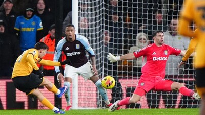 Wolverhampton Wanderers' Rodrigo Gomes, left, scores their second goal during their English Premier League soccer match against Aston Villa in Wolverhampton, England, Friday, Feb. 27, 2026. (Bradley Collyer/PA via AP)