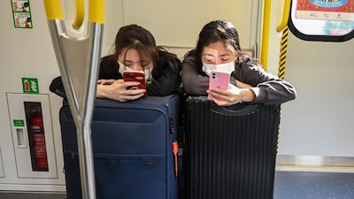 Two girls use their phones on a train as they head to the Lo Wu border control point in Hong Kong. (Representational image/AFP file photo)