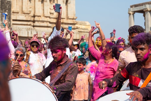 Hampi: Celebrate Holi surrounded by centuries-old temples and surreal boulder landscapes. Hampi offers a unique mix of history and backpacker culture. Drums echo through ruins, travellers gather by the river, and the entire UNESCO site transforms into a colourful, magical playground.