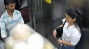 The man carrying the balloons enters the lift.