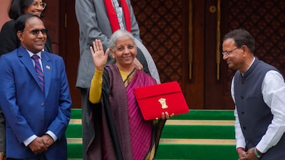 Finance Minister Nirmala Sitharaman shows the digital tablet, enclosed in a traditional red 'bahi-khata' style pouch, before Union Budget presentation on February 1, 2026. (PTI)