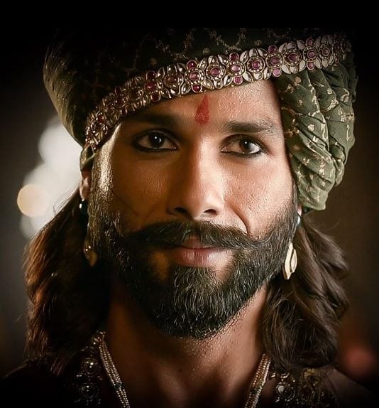 The Royal Warrior (Padmaavat, 2018): As Maharawal Ratan Singh, Shahid embodied Rajputana grace. He underwent a massive physical bulk-up, sporting a regal beard and traditional jewelry, holding his own with a poised, "still" intensity.