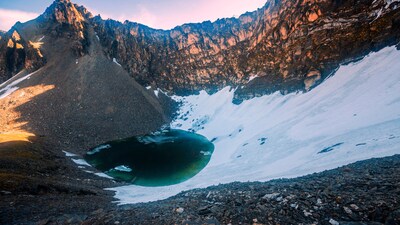 Hidden in the Himalayas, a frozen lake reveals hundreds of human skeletons when the ice melts. Perched over 5,000 metres above sea level, Roopkund is a small glacial water body surrounded by towering peaks like Trishul and Nanda Ghunti. For most of the year, it stays frozen, hiding secrets beneath its icy surface. (Image-iStock)