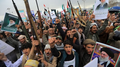 Houthi supporters brandish rifles and hold portraits of Iran's slain supreme leader Ayatollah Ali Khamenei during a rally in solidarity with Iran and Lebanon. (AFP)