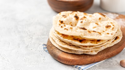 Are your chapatis always hard and uncooked? These simple kitchen tips can help you cook soft, fluffy rotis at home in minutes. (Image: Canva)