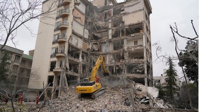 Iranian firefighters use an excavator to clear rubble from a residential building that was hit in an earlier US-Israeli strike in Tehran (Photo: AP)