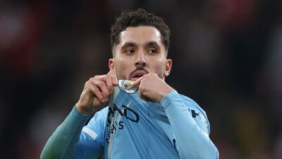 Manchester City's Rayan Cherki points to his club badge as he is substituted during the English League Cup final soccer match between Arsenal and Manchester City in London, Sunday, March 22, 2026. (AP Photo/Richard Pelham)
