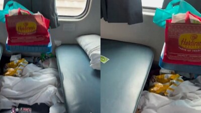 The floor of the train compartment is littered with packets and water bottles. (Photo Credit: X)