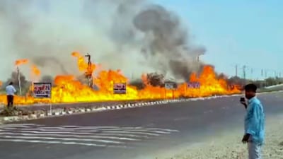 Flames and thick smoke rise from the roadside after a diesel-filled tanker overturned on NH-48. (Image: PTI)