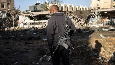 An Israeli security personnel inspects the site of an Iranian missile strike in Dimona on Sunday. (Image: AFP)