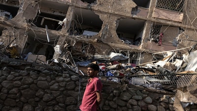 A man walks through the site of an Iranian missile strike in Dimona on March 22, 2026. (Photo: AFP)