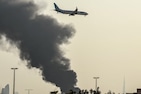 An international low coast FlyDubai aircraft prepares for landing as a smoke plume rises from an ongoing fire near Dubai International Airport in Dubai on March 16, 2026. (Photo: AFP)