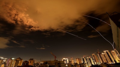Rocket trails are seen in the sky above the Israeli coastal city of Netanya amid a fresh barrage of Iranian missile attacks on March 25, 2026. (Photo by JACK GUEZ / AFP) 