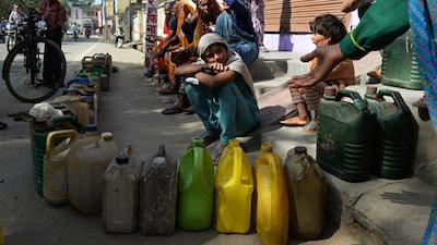 People wait their turn to get subsidsed kerosene oil and wheat outside a government fair shop in Alwar district. (AFP file photo)