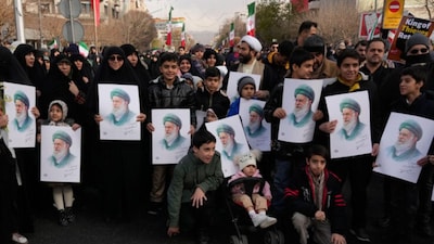 People hold posters of Ayatollah Ali Khamenei during a funeral ceremony for a group of security forces, who were killed during anti-government protests, in Tehran, on January 14, 2026. (AP)