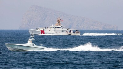 A US Navy L3 Harris Arabian Fox MAST-13 drone boat and the US Coast Guard cutter USCGC John Scheuerman transit the Strait of Hormuz.  (AP File)