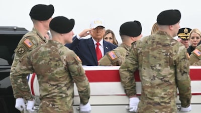 US President Donald Trump salutes as members of a US Army team carry a flagged-drapped transfer case containing the remains of six soldiers killed in Kuwait during war with Iran. (AFP photo)