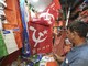 A shopkeeper shows umbrellas and flags with depictions of TMC party logo at his shop, ahead of the West Bengal Assembly elections, in Kolkata. (IMAGE: PTI)