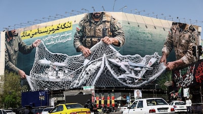  Cars drive near an anti-US billboard, amid the U.S.-Israeli conflict with Iran, in Tehran, Iran. (IMAGE: REUTERS) 
